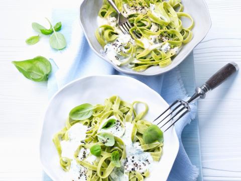 Groene pasta met pestoroomsaus en basilicum