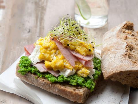 Bruine boterham met ham, roerei en geitenkaas