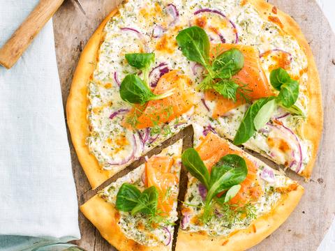 Pizza met zure room, rode ui, zalm en kruiden