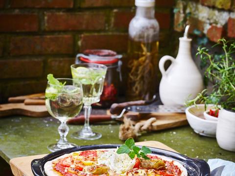 Homemade pizza met artisjok, tomaat en burrata