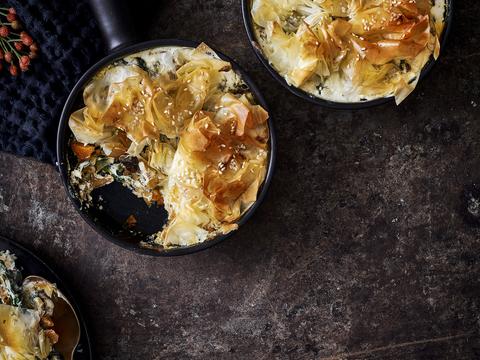 Pompoencurry met spinazie en paddenstoelen onder filodeegdeksel