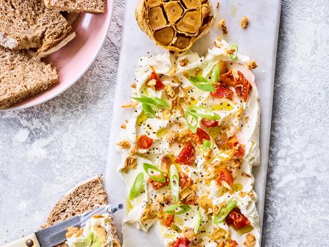 Roomkaas-board met geroosterde knoflook en zongedroogde tomaatjes