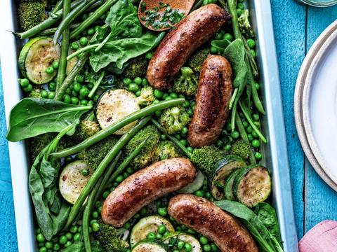 Varkensworstjes op de bakplaat met groene zomergroenten