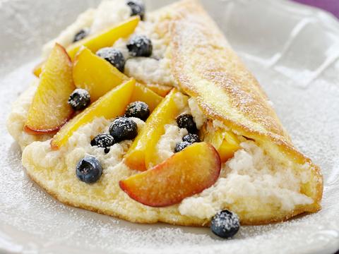 Schuimomelet met perziken en bosbessen