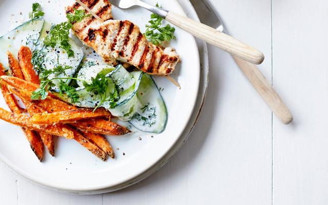 In yoghurt gemarineerde kipsatés met komkommersalade en zoete-aardappelfrietjes