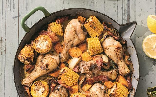 Ovenschotel met drumsticks, maïs, zoete aardappel en spek