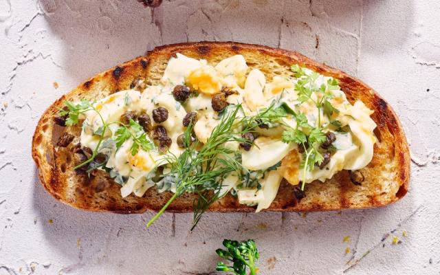 Toast met eiersalade, groene kruiden en krokante kappertjes