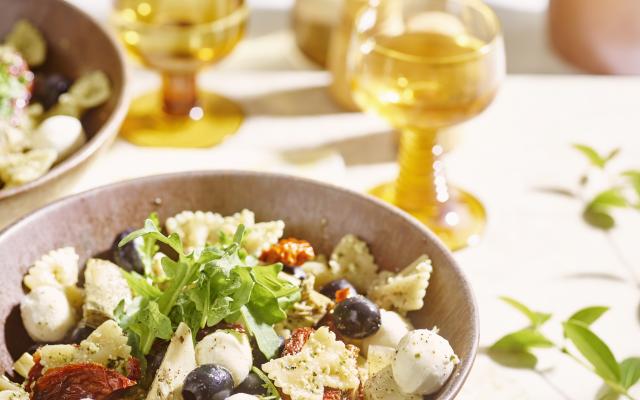 Farfalle met amandelpesto, mozzarella, zongedroogde tomaten en olijven