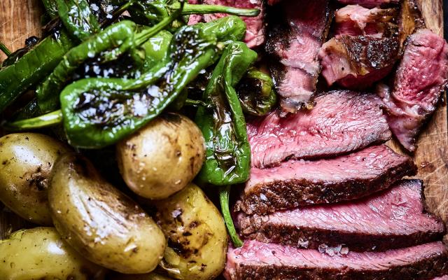 Côte à l’os op de barbecue met gebakken aardappeltjes en padrónpepertjes