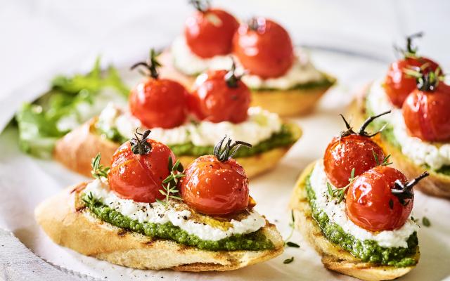 Bruschetta met ricotta, rucolapesto en gepofte tomaatjes