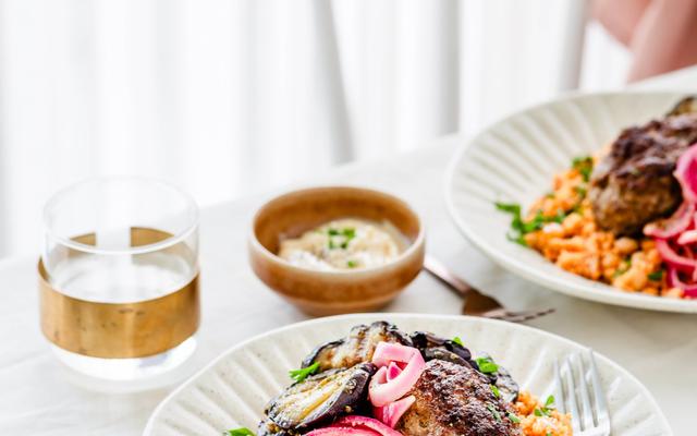 Köfte met tomaten-couscous, gegrilde aubergine en opgelegde rode ui