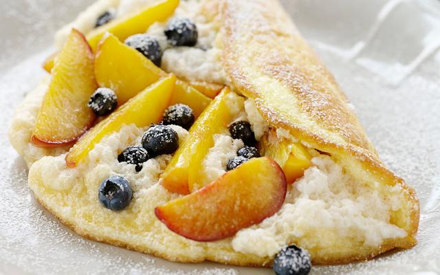 Schuimomelet met perziken en bosbessen