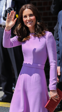 In een lavendelkleurige jurk van Emilia Wickstead met rode clutch van Anya Hindmarch en oorbellen van Kiki McDonough