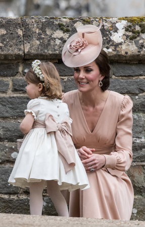 In een nude jurk van Alexander McQueen met hoed van Jane Taylor en oorbellen van Kiki McDonough