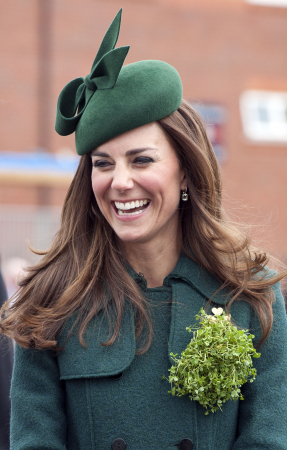 In een smaragdgroene mantel van Hobbs met hoed van Gina Foster en oorbellen van Kiki McDonough