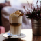 Frozen frappuccino = 3/4 shot espresso, melk, ijs, suiker, chocoladesiroop, slagroom en karamelstroop