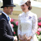 In een witte kanten jurk van Alexander McQueen met clutch van Loeffler Randall en oorbellen in bruikleen van koningin Elizabeth II (de ontwerper van de hoed is niet bekend)