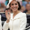 In een crÚmekleurige jurk van Alexander McQueen met hoed van Philip Treacy, halsketting van Mappin & Webb en oorbellen in bruikleen van koningin Elizabeth II
