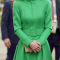 In een felgroene manteljurk van Catherine Walker met clutch van L.K.Bennett en gouden oorbellen van Kiki McDonough