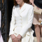 In een crÚmekleurige jurk van Alexander McQueen met hoed van Jane Corbett, oorbellen van Kiki McDonough en clutch van L.K.Bennett