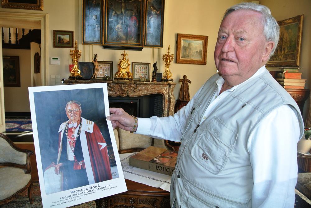 Michel Bohé met een foto van zijn geschilderd portret als Luitenant-Grootmeester van de Hospitaalridders van Sint-Jan en van Jeruzalem.