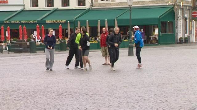 Toeristen verkennen Brugge al joggend