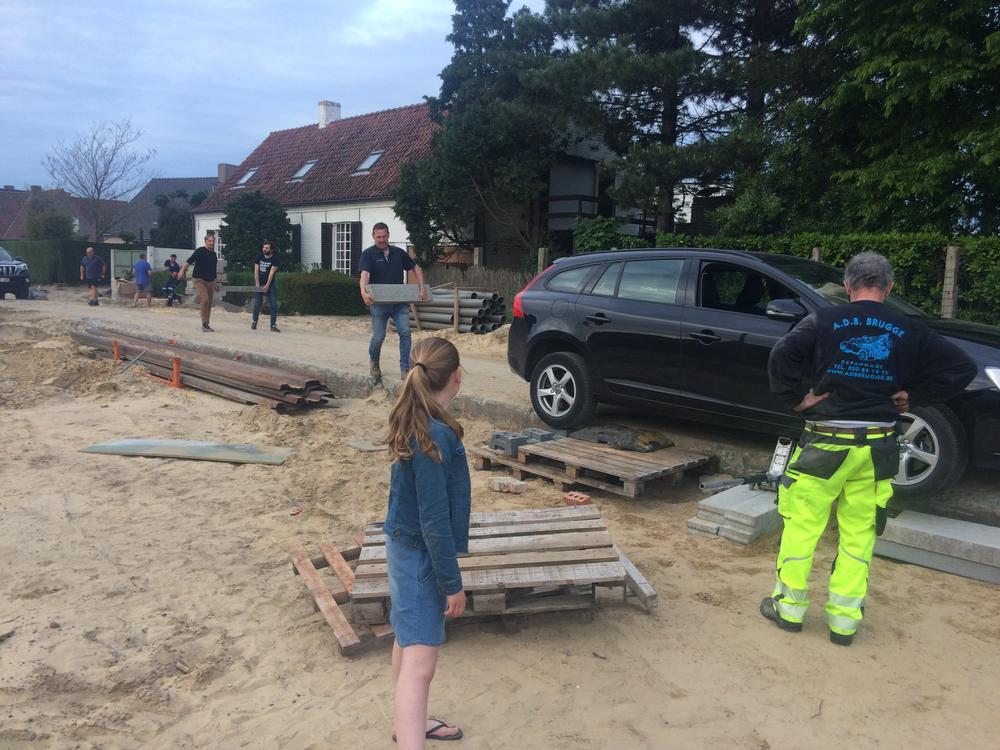 Buren Davy Monteyne en Ludovic Vigneron helpen Joachim Nijs met het aandragen van betonblokken om onder het voorwiel te stapelen.