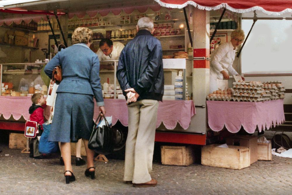 De marktwagen van Zuivelhandel Sint-Hubertus in de jaren 1970 met achter de toonbank Hubert Watty en op weg naar de kartons vol eieren zijn vrouw Bérénice Storme.