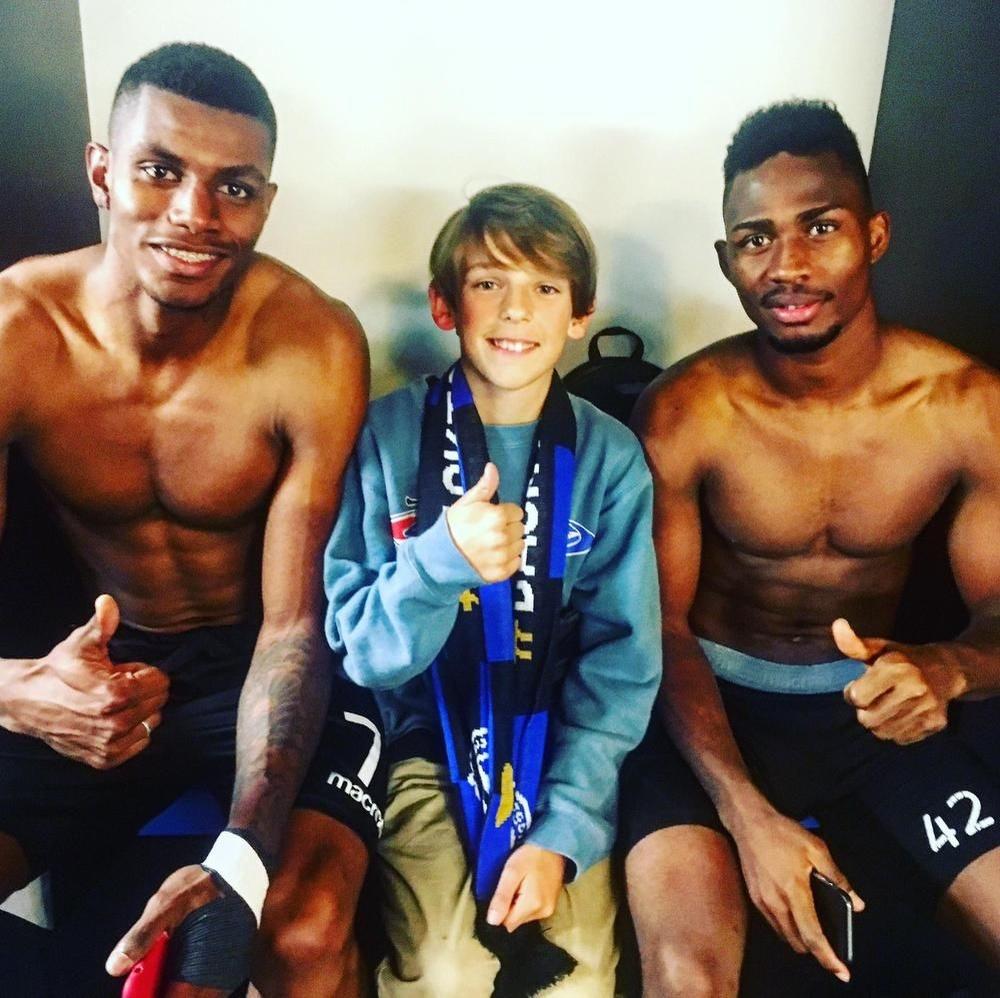 De 12-jarige zoon van Günter Lesage tussen Club-spelers Wesley Moraes en Emmanuel Dennis.