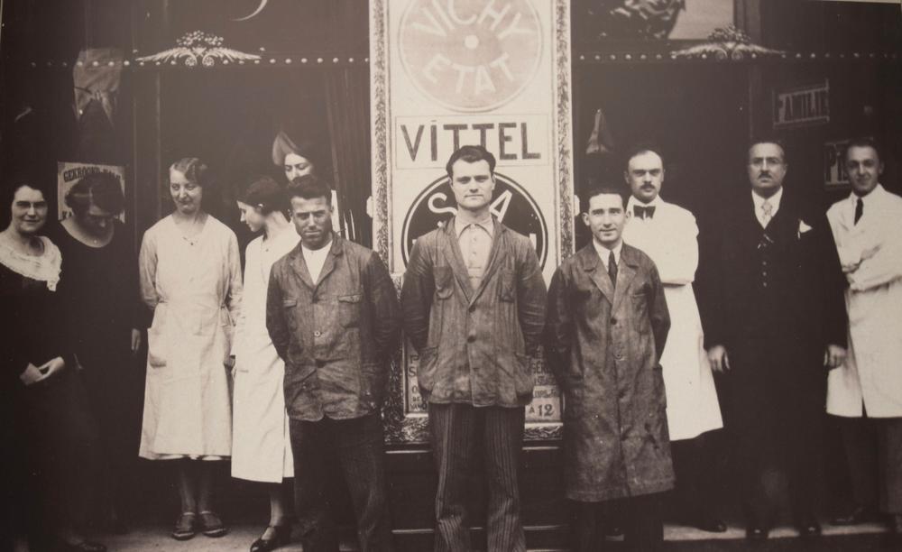 2 = oude foto = Tijdens de florissante jaren 30 waren er 11 medewerkers, inclusief Raymond Copermans (tweede van rechts) en zijn vrouw Yvonne Van Wynsberghe (helemaal links)
