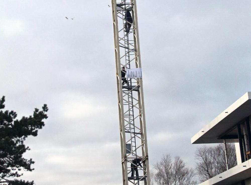 Waaghals kruipt uit protest met spandoek op hoge torenkraan in Koksijde