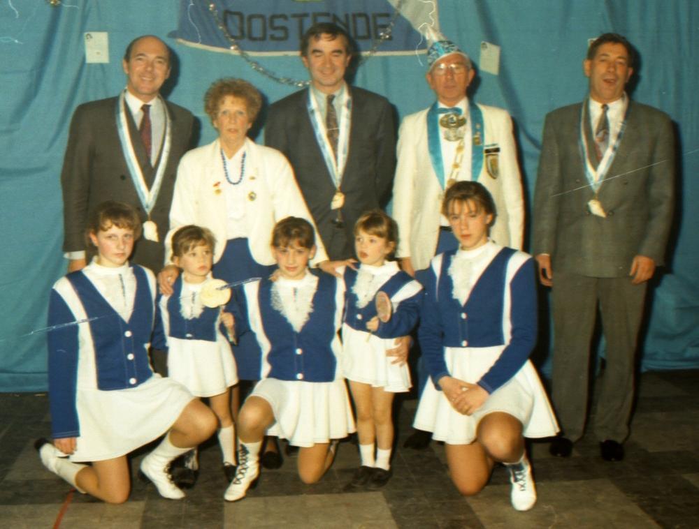 Een beeld uit 1987 met bovenaan schepen Maurice Quaghebeur, schepen Paul Van Laer, voorzitter Robert Dequick en schepen Eddy Tulpin. Onderaan de Wullok Show Girls die een medaille kregen.