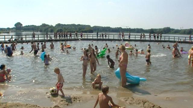 Mensen zoeken afkoeling aan zwemvijver de Gavers in Harelbeke