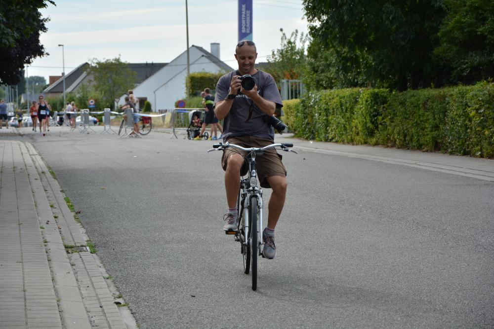 Een bekend beeld: Dries Verhelst op de fiets met zijn fototoestel in de hand. (Foto SM)