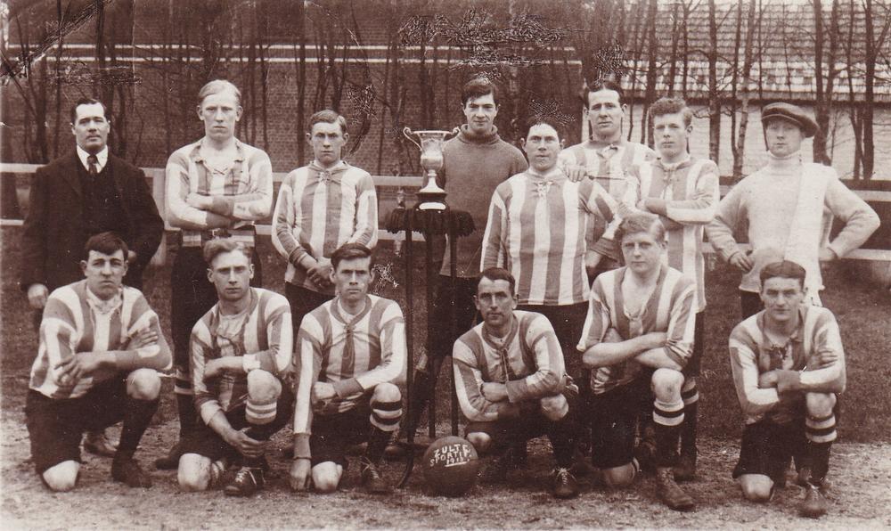 De ploeg van Sportif Zulte op eigen veld in 1913. Staande links paardentrainer Stanton, in het midden zijn zoon keeper Charley Stanton, en uiterst rechts verzorger William Connelly. Zittend rechts van de bal Waregemnaar Aloïs Vanhauwere.