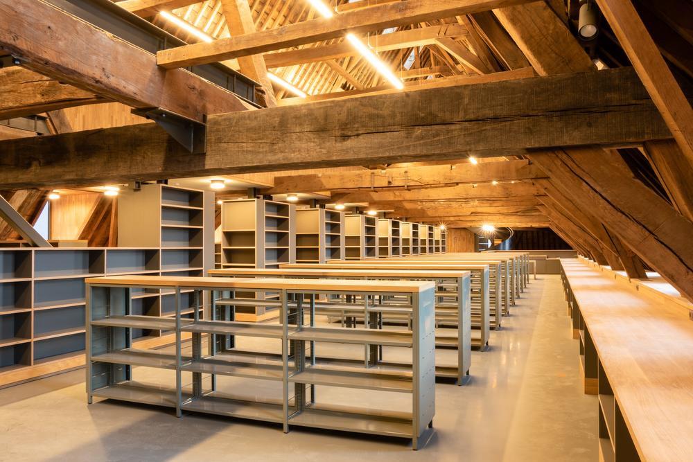 Onder het dakgebinte is de stadsbibliotheek ondergebracht, waarvoor Labo Potteau het meubilair realiseerde.