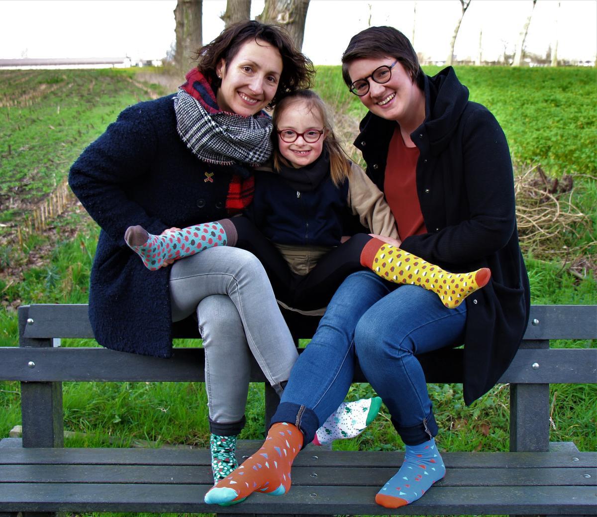 Ester bij haar mama en tante die de sokken tonen. (GF)