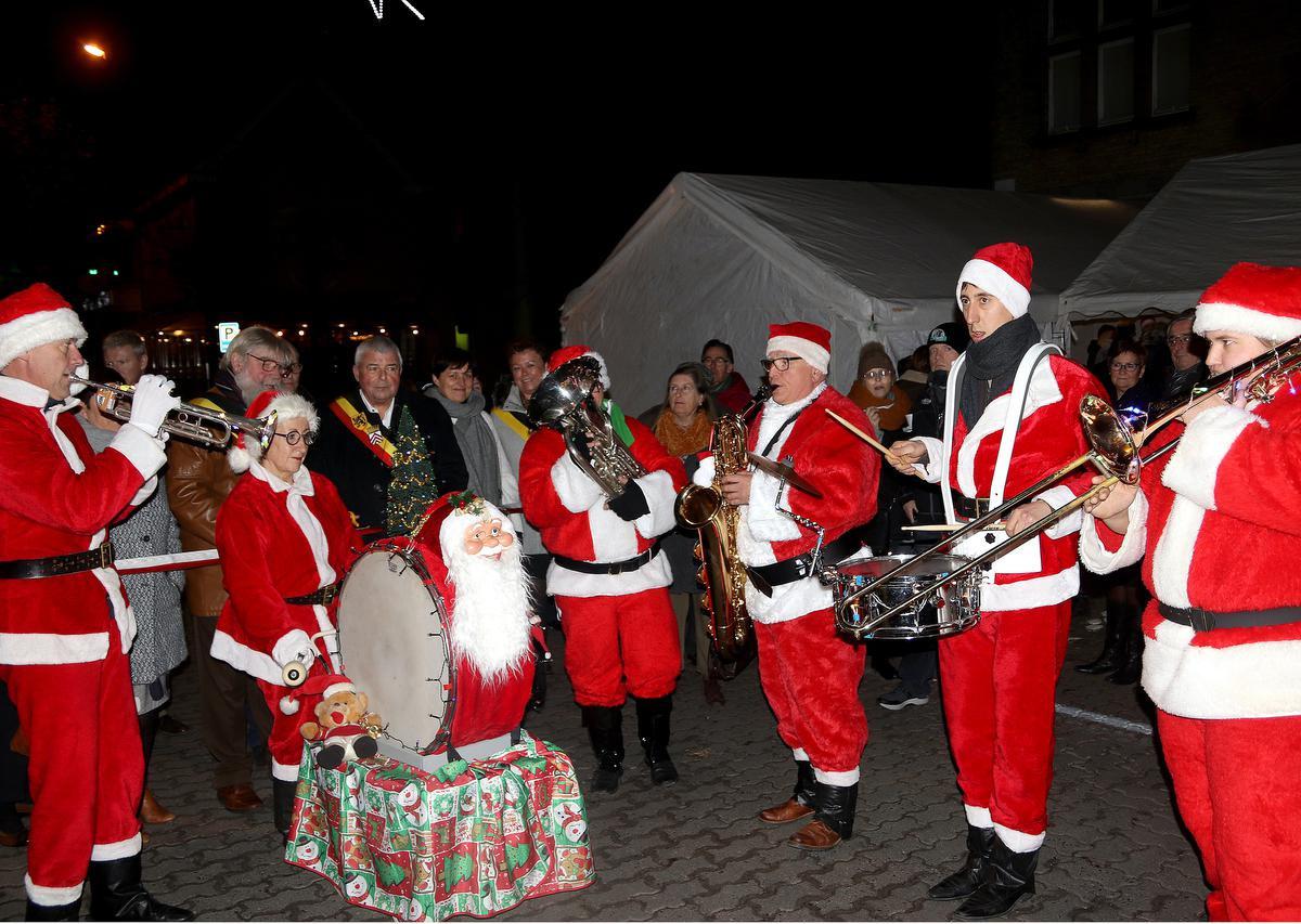 Een sfeerbeeld van een van de vorige edities van de kerstmarkt in Lauwe, met onder andere burgemeester Eddy Lust en schepen Herman Ponnet bij het Rekkems dorpsmuziek.
