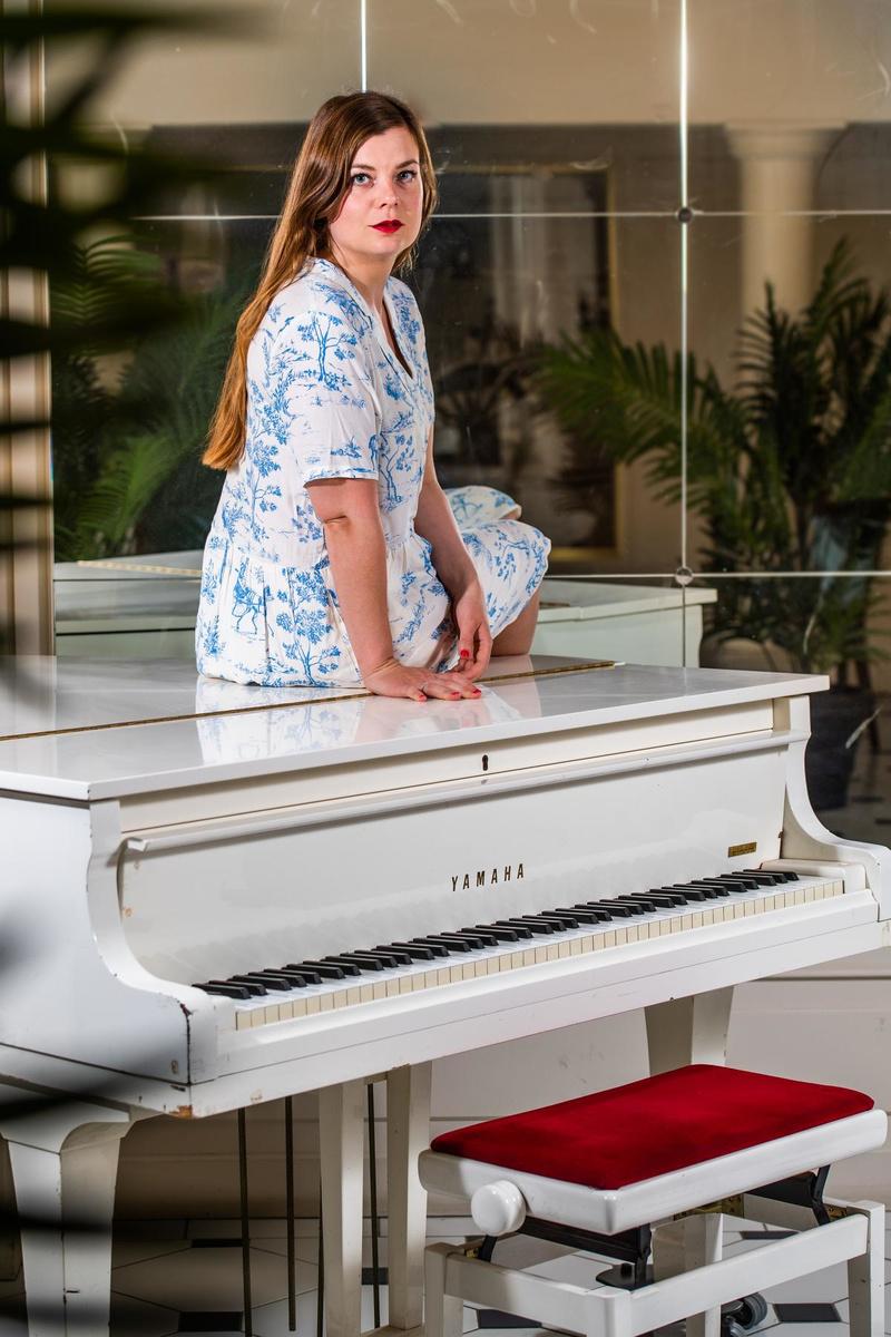 Even poseren voor de fotograaf bij een piano. Ze vindt het maar niets dat ze niet écht mag spelen.