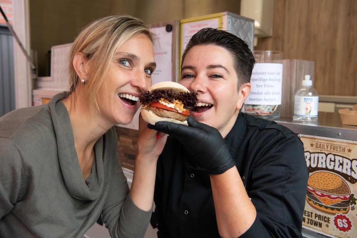Cindy Provyn (links) en Mieke Vandevelde smullen van de Crispy Burger, waarvan de opbrengst integraal naar Fiene Verstraete gaat. Op zaterdag 15 augustus organiseren de twee dames een benefietmarkt voor het meisje.