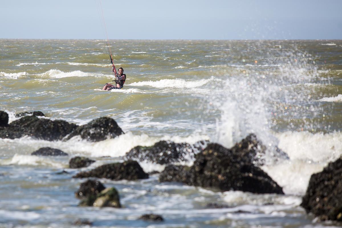 Een kitesurfer in actie voor het strand van Knokke-Heist.