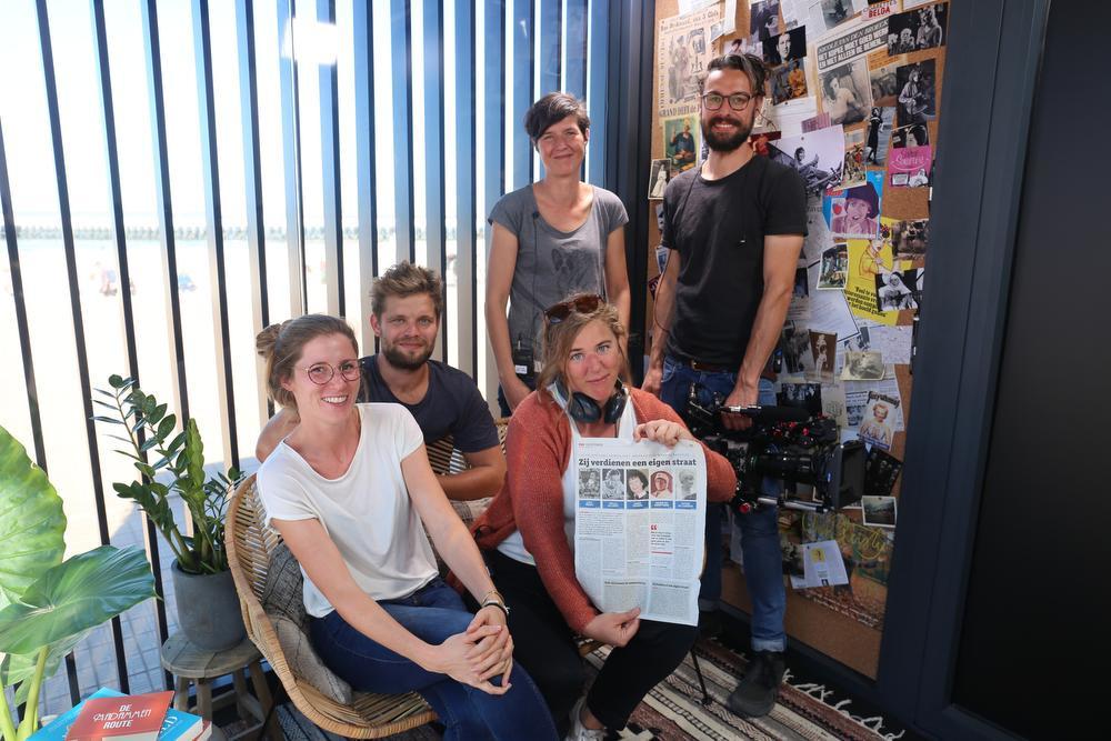 Het team van 'Meer vrouw op straat' met de pagina uit deze krant in de pop-upstudio op het Zeeheldenplein.