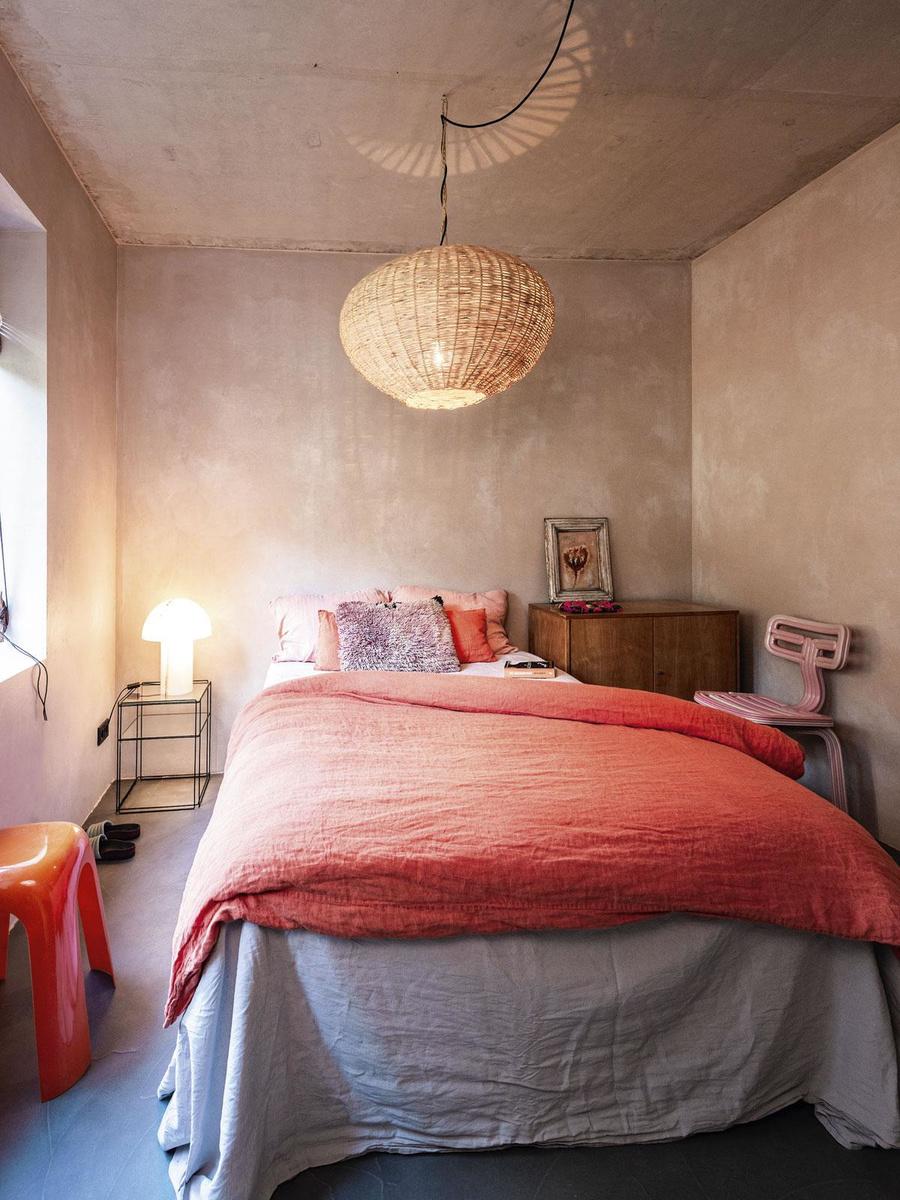 Naast het bed staat een roze Chubby Chair van Dirk Vander Kooij. Op de houten Pastoe-kast rust een schilderij van een lokale Bergense kunstenaar. Het glazen nachtkastje is een ontwerp van de Franse industriële ontwerper Max Sauze, de Mushroom-lamp van Peill & Putzler dient als nachtlamp. De Marokkaanse hanglamp kocht Petra bij Couleur Locale in Knokke. 