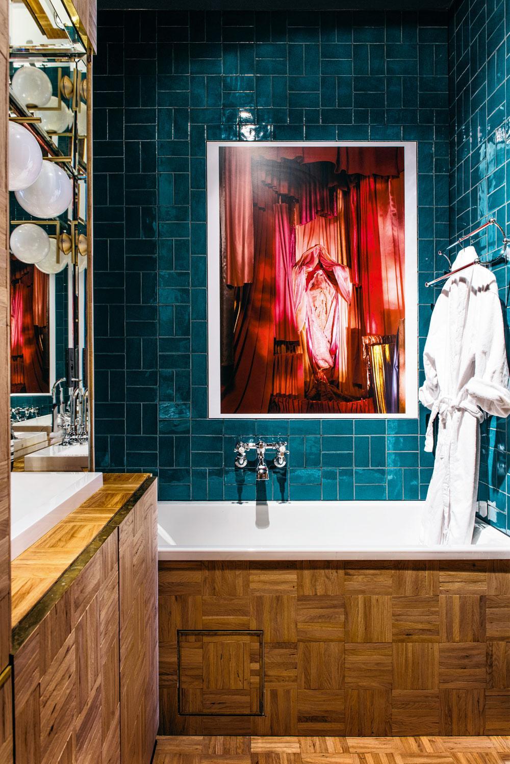 Het werk van fotograaf Athos Burez boven het bad benadrukt de sexy sfeer die in de badkamer moest heersen. De parkettegels op de vloer en de wanden van de badkamer werden online gevonden.
