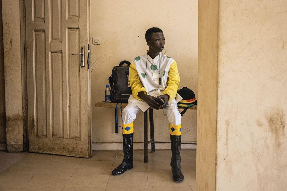 Dans les vestiaires du plus grand hippodrome du Sénégal, Ndiaw Macodou Diop, à Thies, le jockey à la casaque bleu et or de l'écurie Lambafar se concentre avant d'entrer en piste.