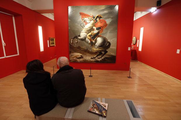 Des visiteurs observent le portrait de Napoléon 1er réalisé par l'artiste Jacques Louis David lors de l'exposition 
