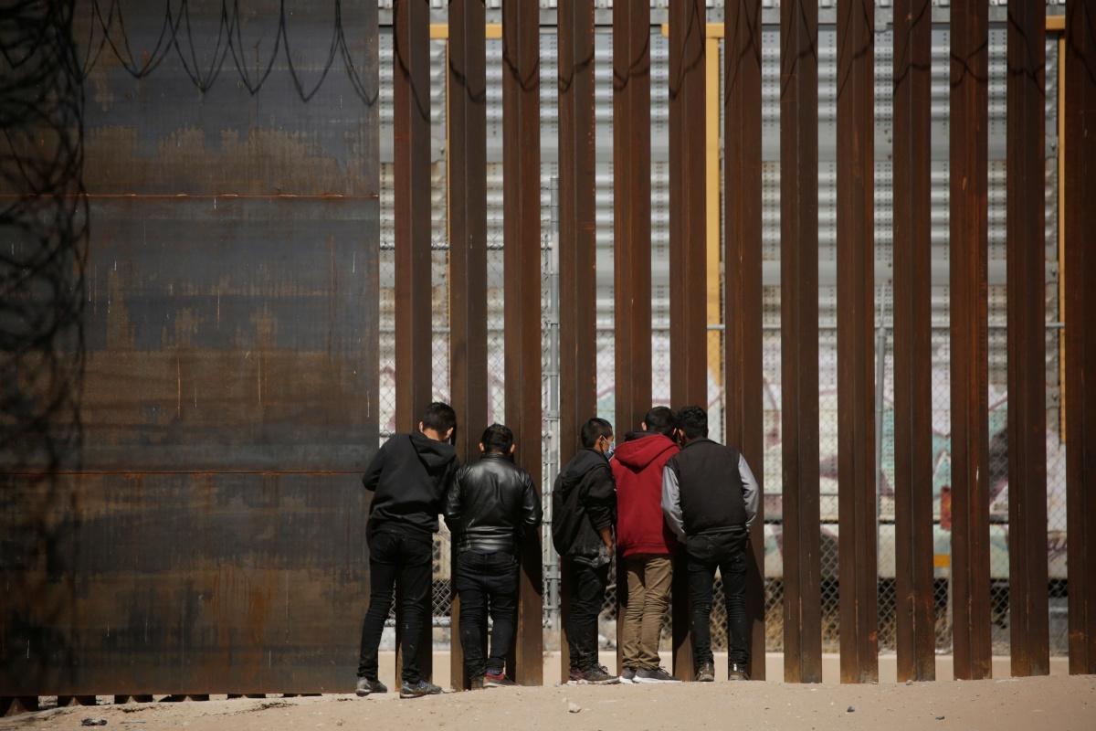 Asielzoekers trachten zich in te leveren aan de Amerikaanse grenswacht bij de Amerikaanse stad El Paso, 14 maart 2021