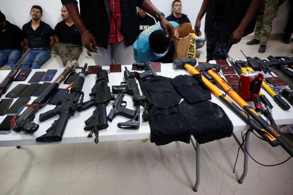 Vermoedelijke verdachten van de moordaanslag op de Haïtiaanse president worden met hun wapens aan de pers getoond. 