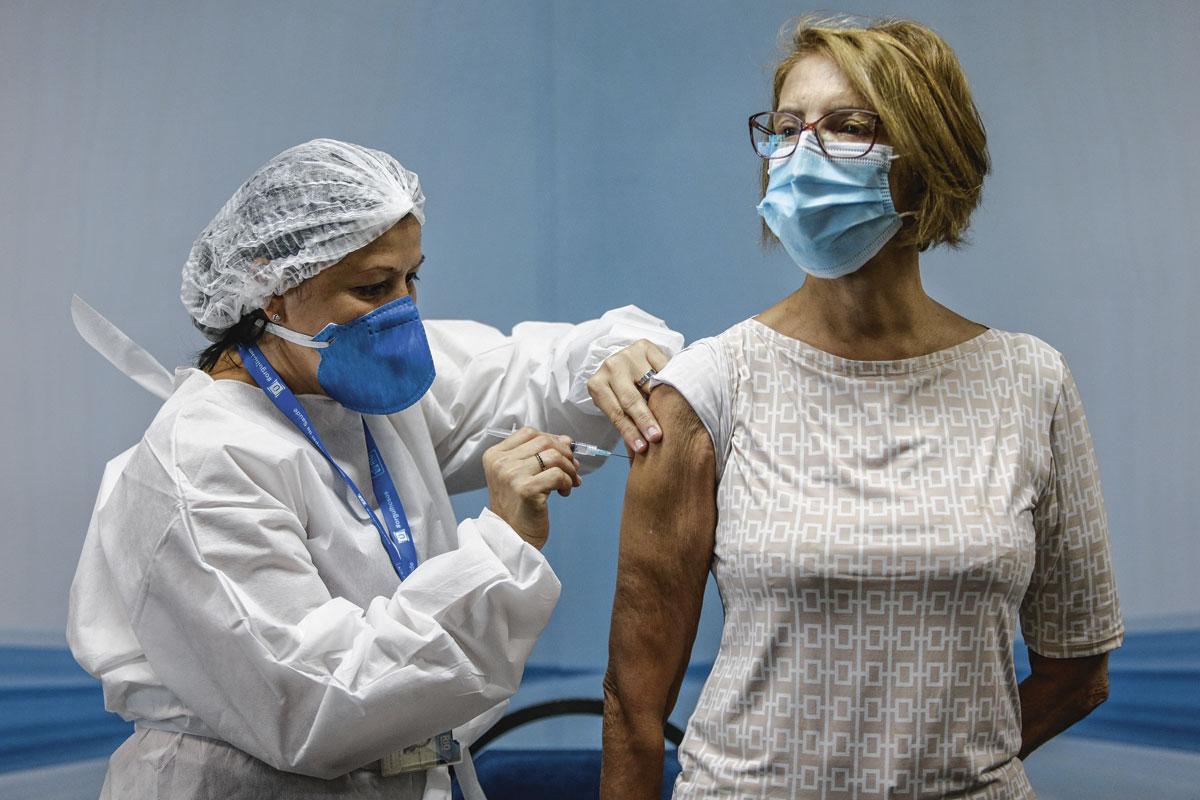 Een vrouw in Rio de Janeiro wordt gevaccineerd. Het ene vaccin werkt beter tegen een bepaalde variant dan het andere.