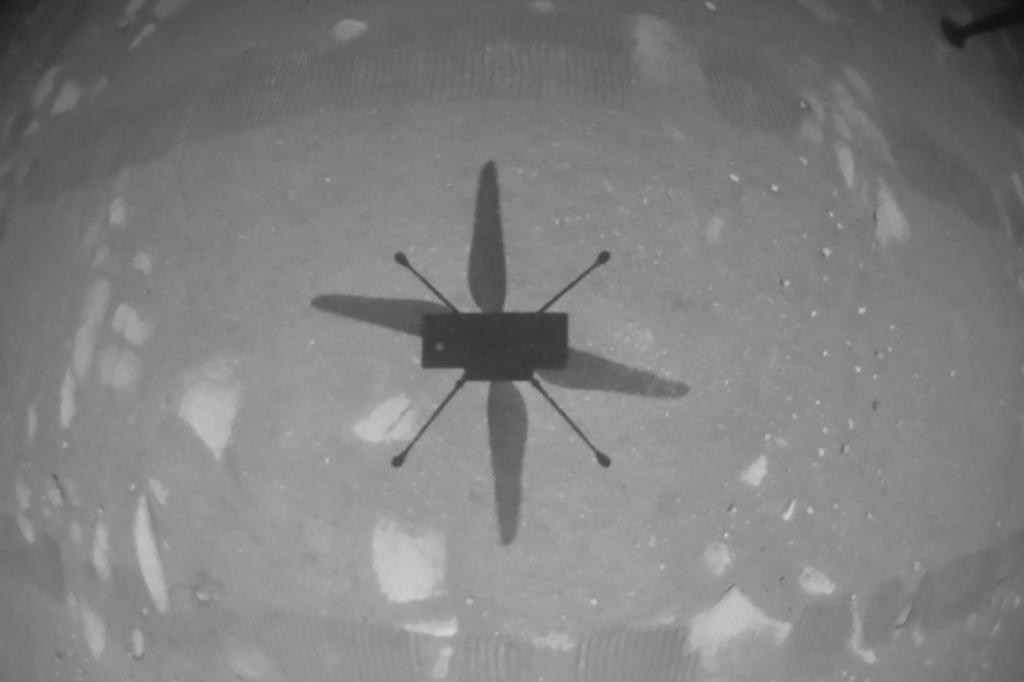 Ingenuity stuurde een zwart-witfoto door waarop de schaduw van het toestel te zien is op het Marsoppervlak.